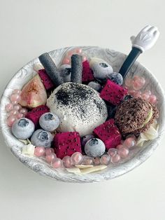 a bowl filled with different types of desserts on top of a white tablecloth