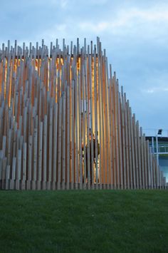 a large wooden structure sitting on top of a lush green field