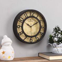 a clock that is on the wall next to a potted plant and vase with flowers