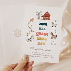 a person holding up a card with farm animals on it