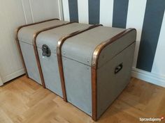 two suitcases sitting on the floor in front of a striped wall