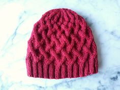 a red knitted hat sitting on top of a marble counter