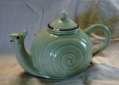 a green teapot with a spiral design on it