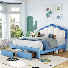 a child's bedroom with blue and white furniture, cactus wall art, and large windows