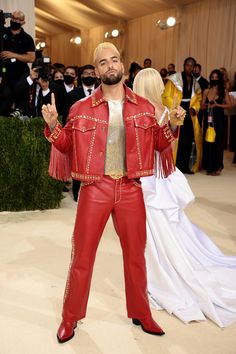 man in red leather suit and gold shirt posing for the camera at the mete