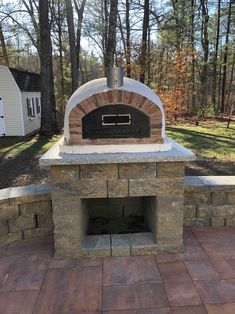 an outdoor pizza oven built into the side of a brick wall