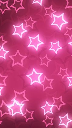 pink and white stars on a red background with blurry lights in the foreground