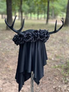 the antlers are adorned with flowers and black fabric for this headdress display