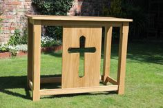 a wooden box with a cross on it in the grass