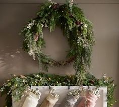 christmas stockings hanging on a mantle with greenery