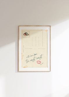 a white wall with a framed postcard on it