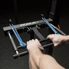 a man is working on some equipment in the gym with two handles and one hand