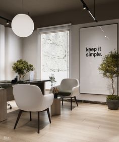 an office with two chairs and a desk in front of a poster that says keep it simple