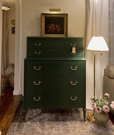 a green dresser sitting in the corner of a living room