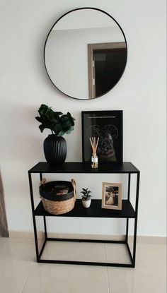 a black shelf with a mirror and plants on it next to a potted plant