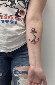 a woman's arm with an anchor tattoo on it