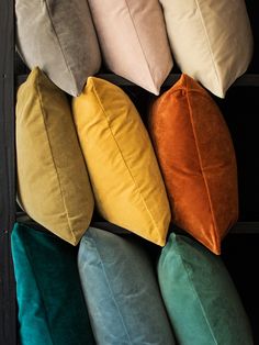 several different colored pillows stacked on top of each other