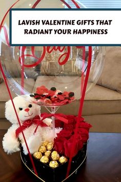 a teddy bear sitting next to a basket filled with chocolates and roses in front of a sign that says lavish valentine gifts that radiant your happiness