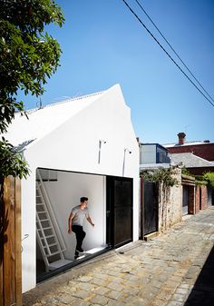 a man walking up the side of a white building