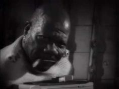 a man with his head on top of a stack of books in black and white