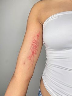 a woman with a red tattoo on her arm