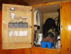 the inside of a wooden cabinet with many items in it