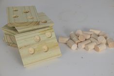 a wooden box and some pieces of wood on a white surface with one piece missing