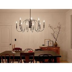 a chandelier hangs over a dining room table