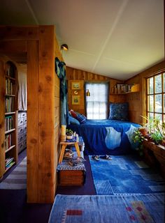 a bedroom with wood paneling and blue carpet