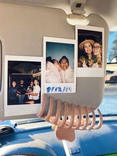 some pictures hanging on the side of a car with photos attached to it's hooks