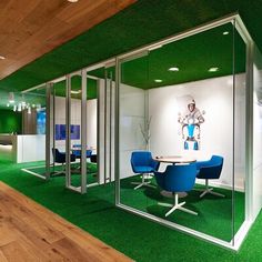 an office with green carpet and glass walls