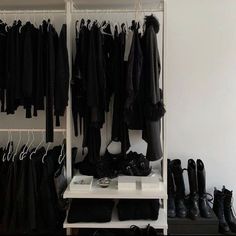 an organized closet with black clothes and shoes