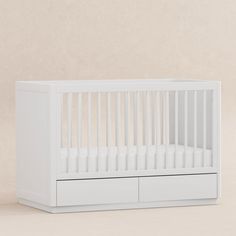 a white crib with two drawers on the bottom and one drawer in the middle