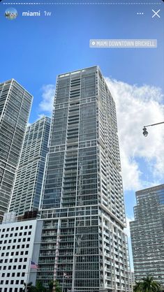 the tall buildings are next to each other in front of blue skies and white clouds