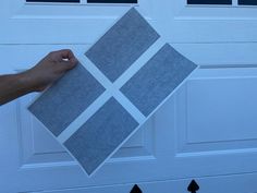 a person holding up a piece of paper with squares on it in front of a garage door