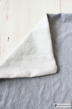 a piece of cloth is laying on top of a wooden table with a white background