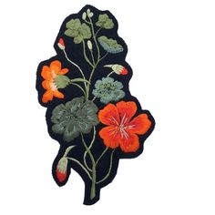 an embroidered patch with flowers and leaves on black fabric, in the shape of a rectangle