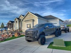 a large truck parked in front of a house with mountains in the backgroud