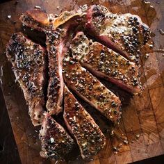 steak sliced up on a cutting board with seasoning sprinkled around it's edges