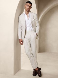 Designed with warm climates in mind, this sleek white suit is cut from an herringbone fabric that blends together soft cotton and luxurious linen.  Here, we left the jacket unlined through the back for even better breathability.  Tailored Slim Fit: More relaxed than our Slim Fit, this Italian cut style has a softer shoulder construction.  Notch lapel with 2-button front.  Four exterior pockets, three interior pockets.  Single back vent.  Lined sleeves, shoulders, and front body, unlined at back.