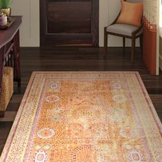 a living room filled with furniture and a rug on top of a hard wood floor