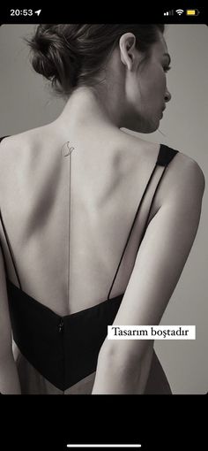 the back of a woman's bra with an arrow tattoo on her upper arm