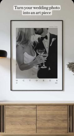 a framed photograph hanging on the wall next to a dresser with a vase in front of it