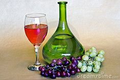 a glass of wine next to a bottle and some grapes