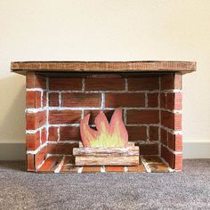 a fire place made out of bricks and wood with flames coming out of the top