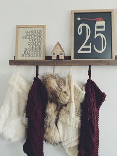 a number twenty five hanging on a wall with some sweaters and mittens in front of it