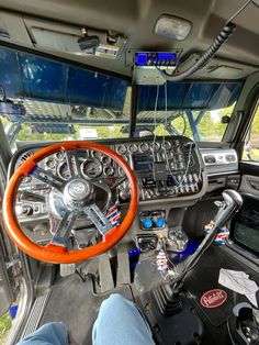 the interior of a vehicle with an orange steering wheel