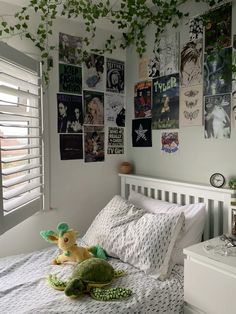 a bedroom with posters on the wall and a stuffed animal laying on it's side