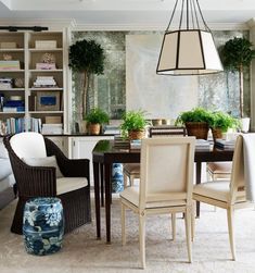 the dining room table is surrounded by wicker chairs and potted plants in pots