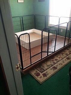 a room that has some kind of cage on the floor in front of an open door